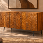Angled view of the Lunar Spec bar cabinet in a warm brown wood finish, showing three textured doors, a smooth top, visible grain along the side and dark tapered legs.