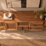 Elevated view of the Labyrinth bar cabinet in a warm brown wood finish, showing a broad top with visible grain, stepped rectangular patterns across the front and tapered legs.