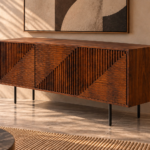 Angled view of the Rhythm bar cabinet in a warm brown wood finish, showing three grooved doors with diagonal divisions, a smooth top and right side, and slim dark legs.