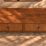 Elevated view of the Rosette bar cabinet in a warm brown wood finish, with a broad grained top, four doors forming two floral patterns, dark round knobs and short square legs.
