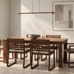 Angled view of the TERRA dining table in a warm brown wood finish, with a rectangular top and broad square legs, surrounded by six chairs with slatted backs and beige upholstered seats.