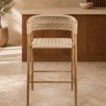 Front view of the BAR GARDENIA chair with a natural-finished acacia wood frame, handwoven rope seat, curved backrest and integrated arms.