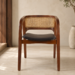 Front view of the CAFFEINA chair with a warm-finished acacia wood frame, natural cane backrest and black upholstered seat.