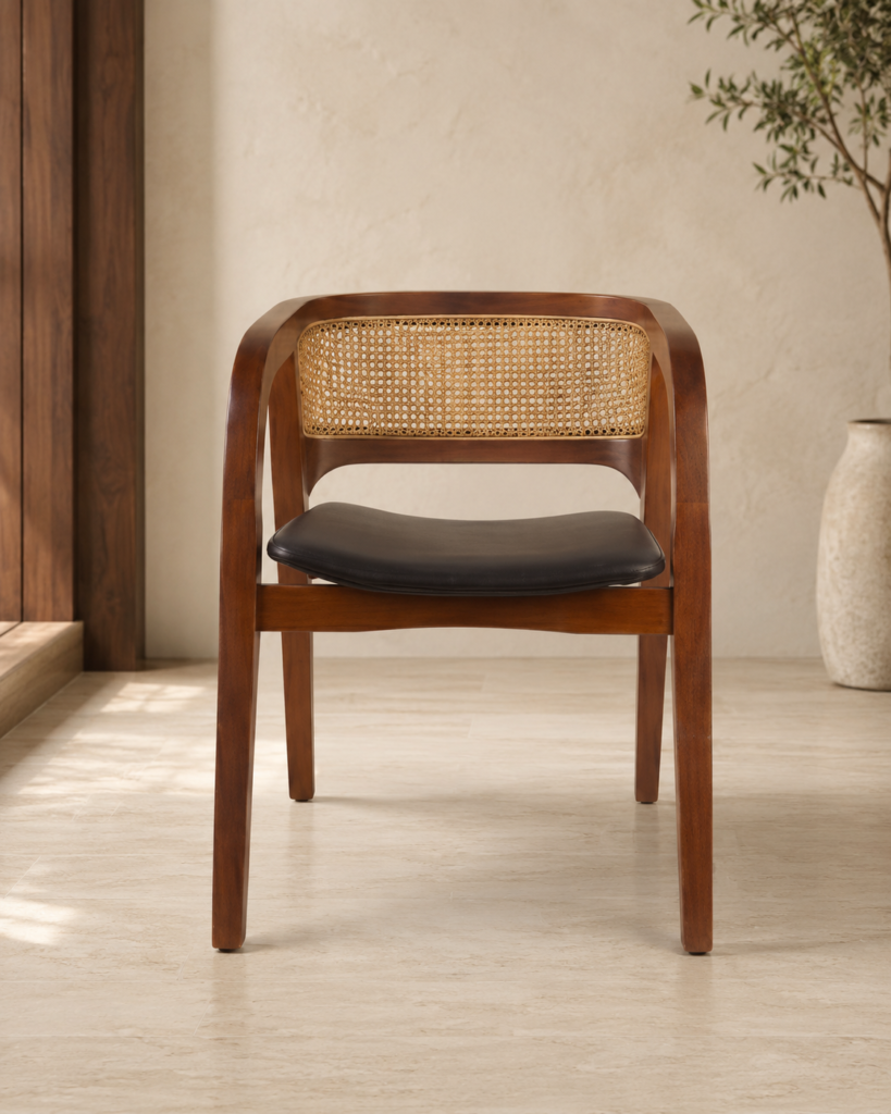 Front view of the CAFFEINA chair with a warm-finished acacia wood frame, natural cane backrest and black upholstered seat.