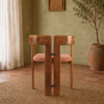 Rear view of the TRIMESTER chair, showing its solid acacia wood construction, twin geometric back sections and muted terracotta upholstered seat.