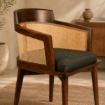 Angled rear view of the Caneya chair featuring a dark Caneya wood frame, natural cane backrest and upholstered seat.