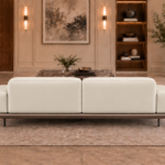 Rear view of the Continentale sofa in ivory Phantom 102 upholstery, with two broad back panels, low padded arms, a brown base and slim dark legs.