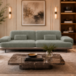 Front view of the Continentale sofa in sage-green Aston 922 upholstery, with two broad seats, padded arms, lumbar cushions and a slim brown base.