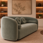 Angled side view of the Formosa sofa in sage-green Giza 116 upholstery, showing its rounded outer arm, wraparound back and matching cushions.