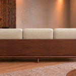 Rear view of the Grand Turismo Dark Wood sofa, featuring three cream patterned back cushions, a broad dark brown wooden panel with visible grain, rounded armrests and tapered legs.