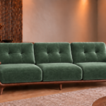Front view of the Grand Turismo Dark Wood three-seater sofa in forest green Aston 921 patterned fabric, with rectangular backrest stitching, broad wooden armrests, curved side panels and tapered legs.