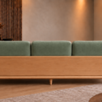 Rear view of the Grand Turismo sofa with three sage green Aston 922 fabric back cushions, a broad light wood panel, rounded armrests, curved lower frame and tapered legs.