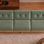 Overhead view of the Grand Turismo sofa in sage green Aston 922 patterned fabric, showing three separate seats, rectangular stitching on the back cushions and broad light wood armrests.