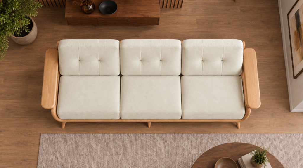 Overhead view of the Grand Turismo three-seater sofa in ivory Aston 902 fabric, showing three equal seat cushions, stitched back cushions, broad wooden armrests and a rounded light wood frame.