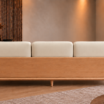 Rear view of the Grand Turismo sofa with three ivory Phantom 102 leatherette back cushions, a broad wooden back panel, rounded armrests, a light teak finish and tapered legs.