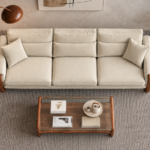 Top view of the Madeira three-seater sofa in cream patterned Amy 904 upholstery, showing three seat cushions, divided back cushions, two matching side pillows and padded arms edged with a teak finish.