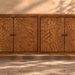 Front view of the Rosette bar cabinet in a warm brown wood finish, with two circular floral patterns across four doors, dark round knobs, a rectangular frame and short square legs.
