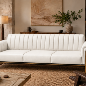 Front view of the Venetia three-seater sofa in white leatherette, with three separate seat cushions, a vertically channelled backrest, rounded arms and gold-finish metal supports above a dark base rail.