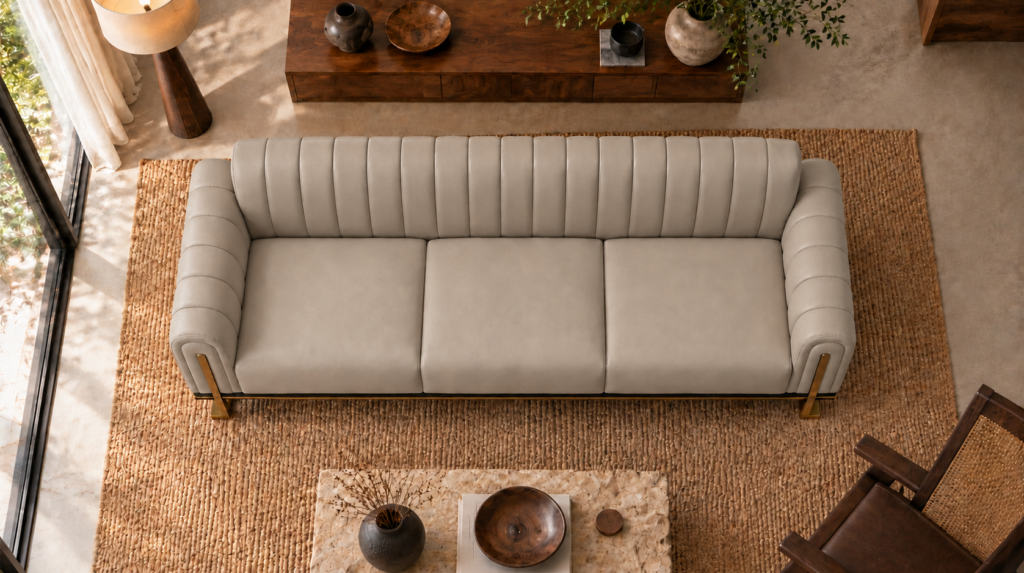 Overhead view of the Venetia sofa in light taupe leatherette, showing three equal seat cushions, a vertically channelled backrest, rounded channelled arms and gold-finish supports at the front corners.